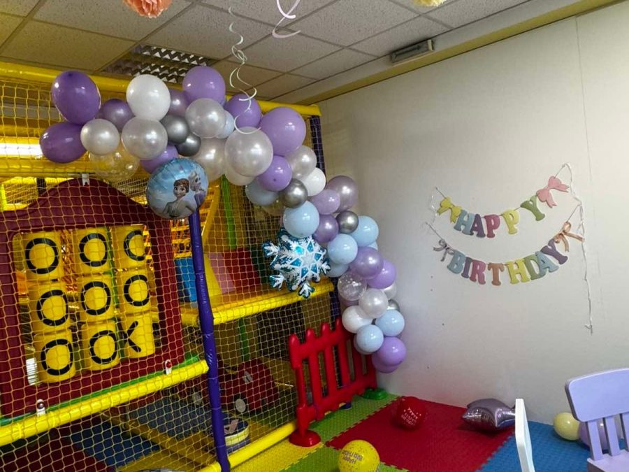 Кът с надпис Happy Birthday, лилаво-бял балонен свод и топки по цветния под